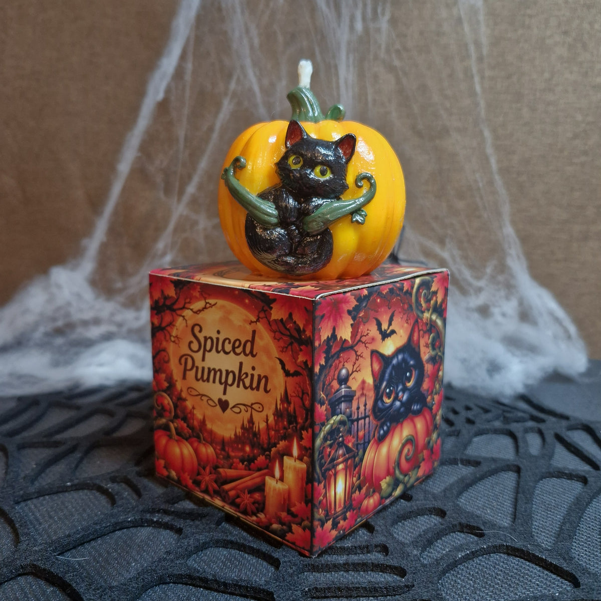 Bougie citrouille et chat noir posée sur son coffret Spiced Pumpkin