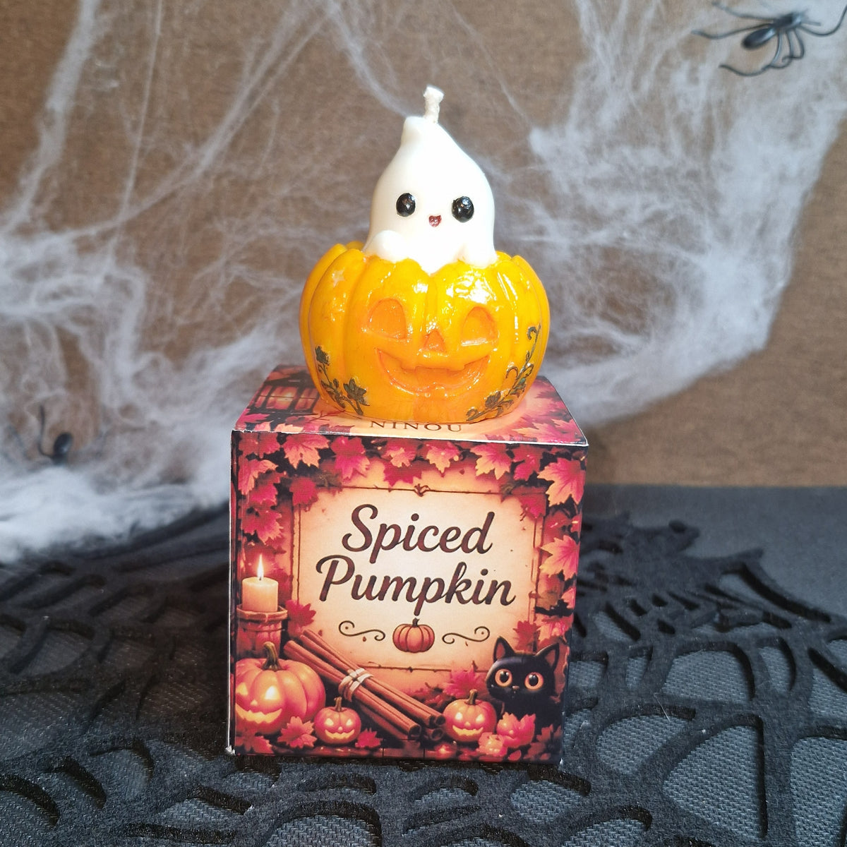 Bougie petit fantôme posée sur son coffret Spiced Pumpkin