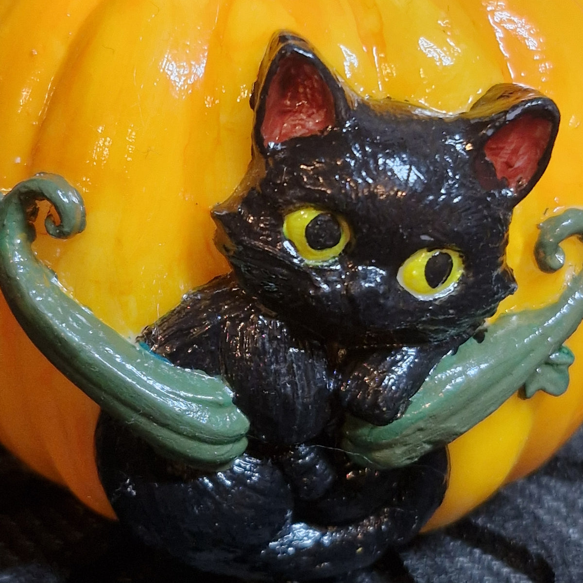 Gros plan sur le chat noir peint à la main sur la bougie citrouille