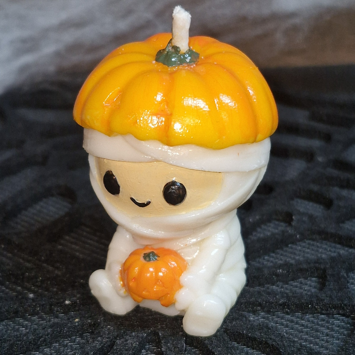 Bougie Halloween Momie citrouille, petite momie coiffée d’une citrouille tenant une mini-citrouille